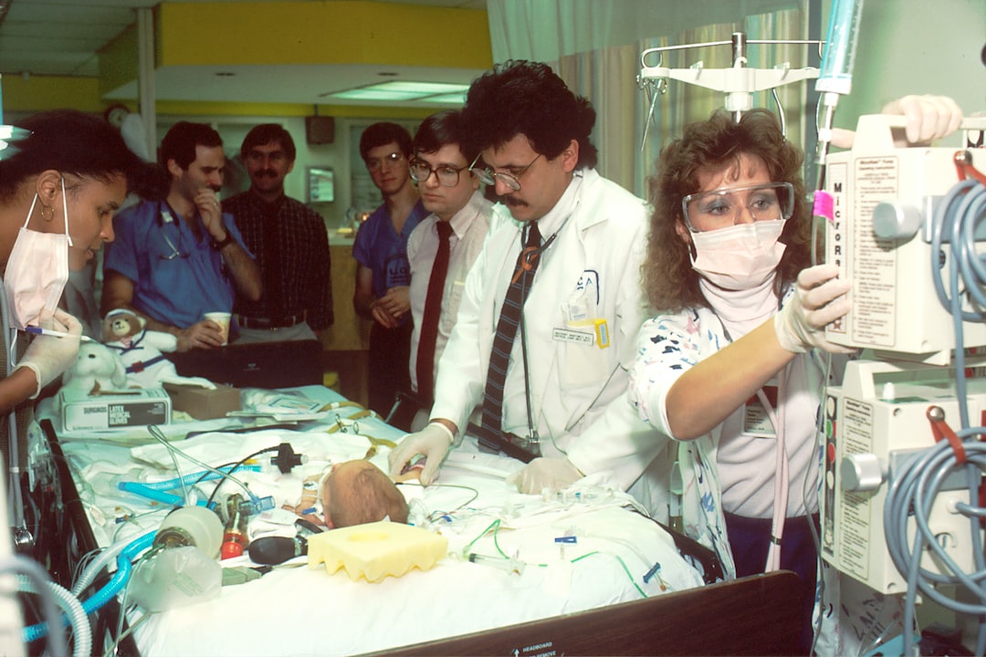 Doctors Examine Infant. A group of doctors examine an infant in the intensive care unit (ICU). Photographer Bill Branson